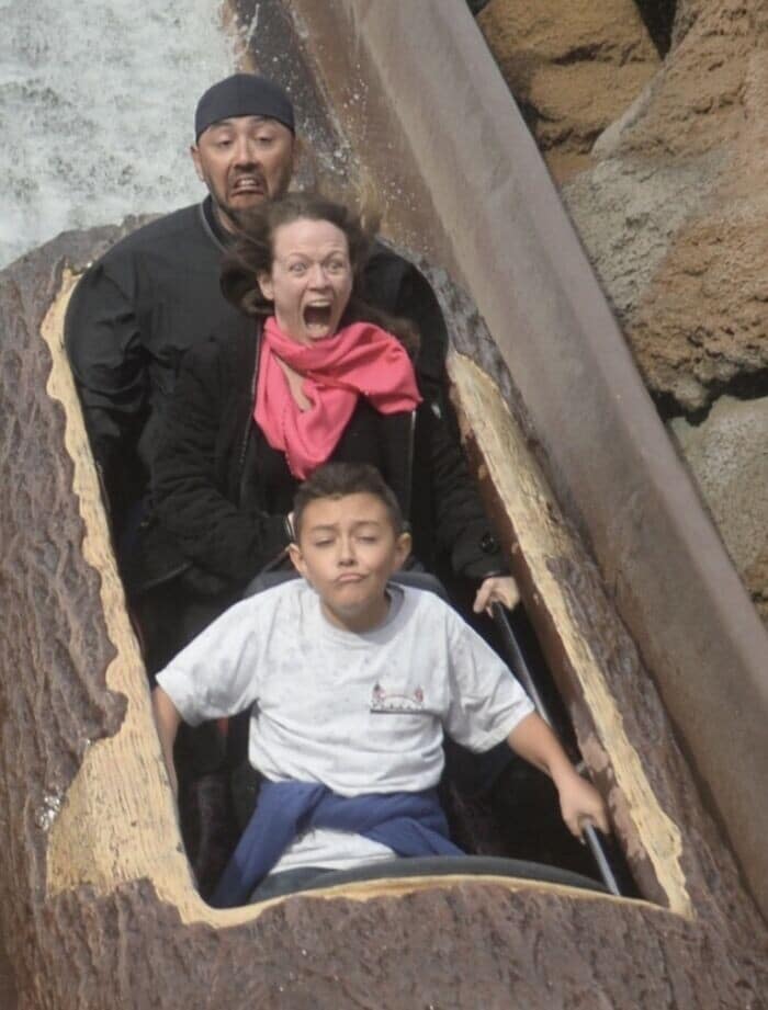 A funny rollercoaster picture of a family on a log flume, showing three completely different reactions to the drop.