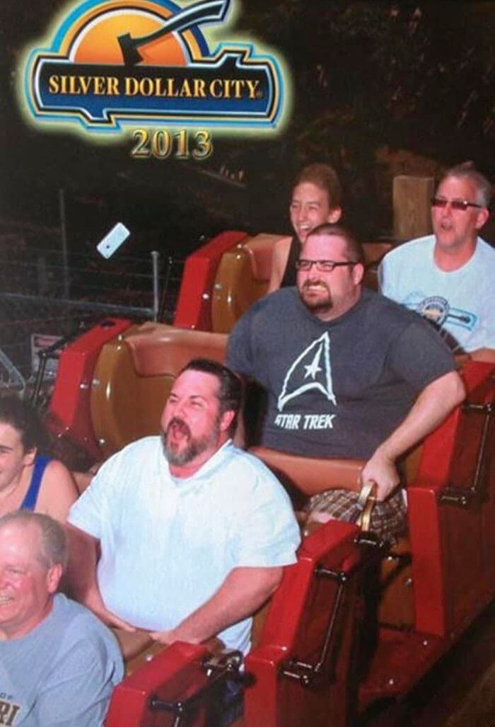 A funny rollercoaster picture that captured the exact moment a person's cell phone flies out of their pocket.