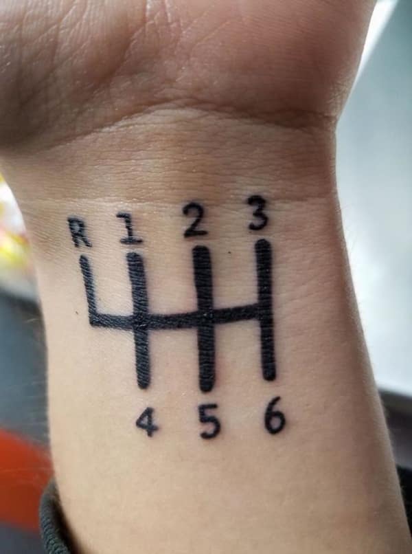 Minimalist manual transmission gear shift pattern tattoo inked on a wrist.