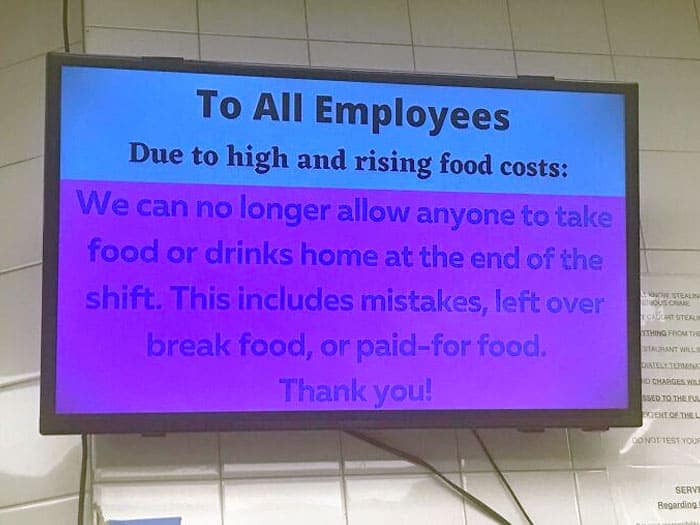 Digital sign banning employees from taking leftover food home due to rising costs.