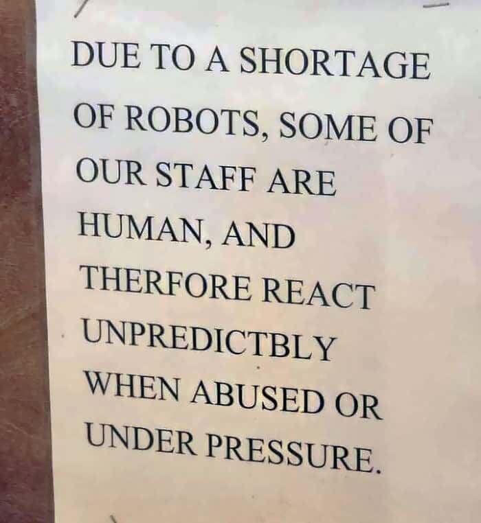 Sign apologizing for human staff reacting unpredictably to abuse due to robot shortage.