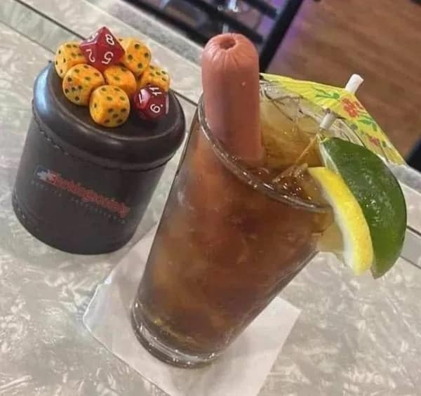 A hilarious meme of a cursed drink, a glass of iced tea garnished with a full hot dog, lemon, and umbrella.