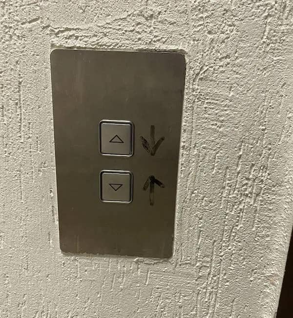 A funny meme of a design fail, showing an elevator button panel where someone drew arrows to fix the confusing layout.