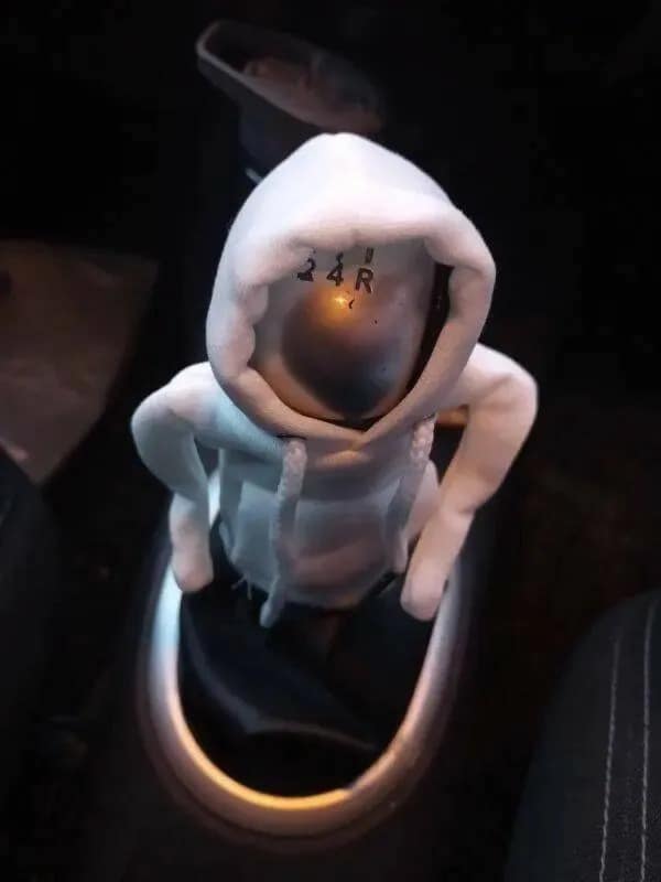 A funny meme of a car's stick shift wearing a tiny, perfectly-fitted white hoodie sweatshirt.