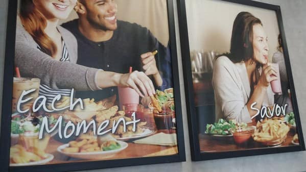 Frustrating restaurant signs where one says "Each Moment" and the other just "Savor."