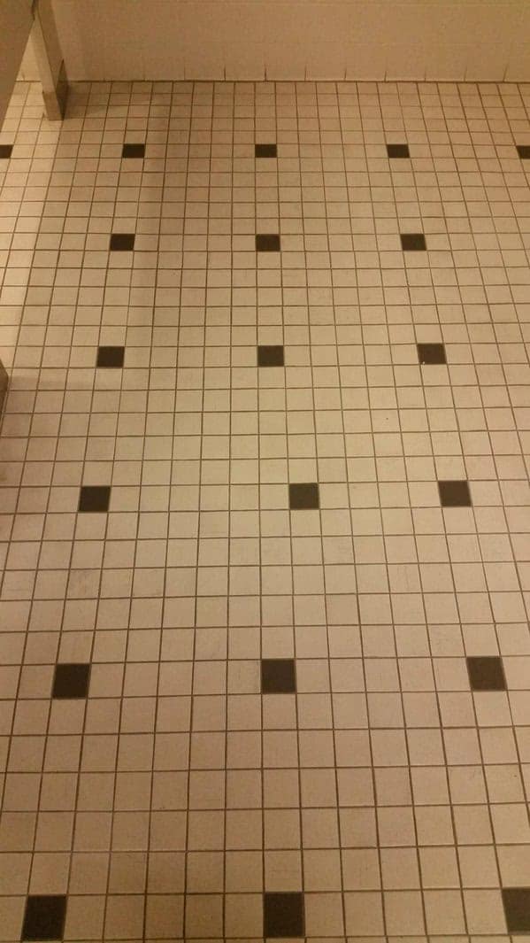 Frustrating tile floor pattern where one black tile in the center is misaligned with the rest.