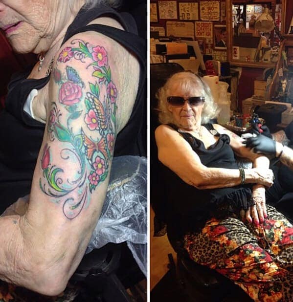 A very cool elderly woman in sunglasses and leopard-print pants getting a colorful floral sleeve tattoo.