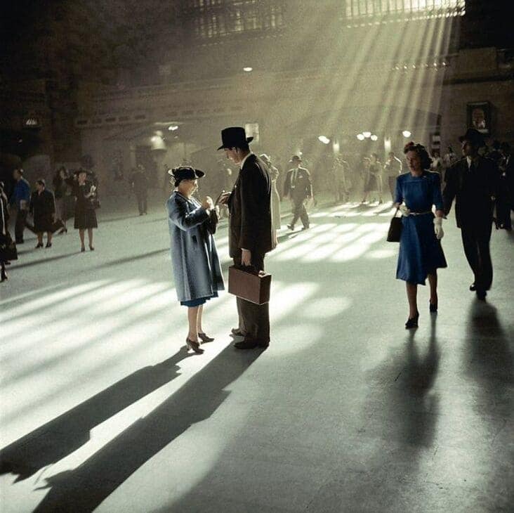 An accidental renaissance painting photo of sunbeams streaming into a train station illuminating people walking