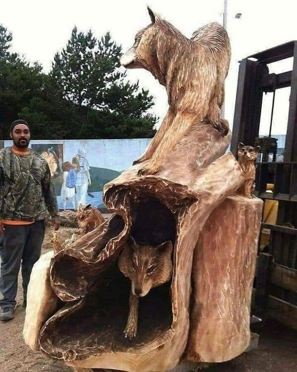 This amazing woodworking sculpture features wolves emerging from a giant log