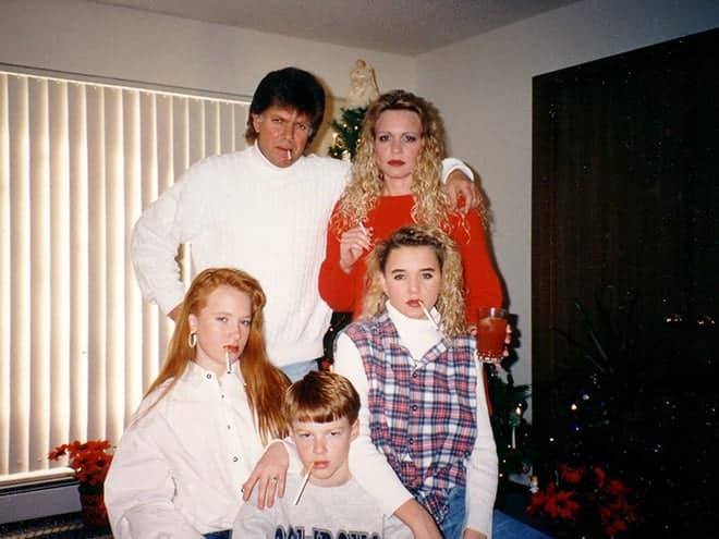 An awkward family christmas photo of a family posing with cigarettes in their mouths.