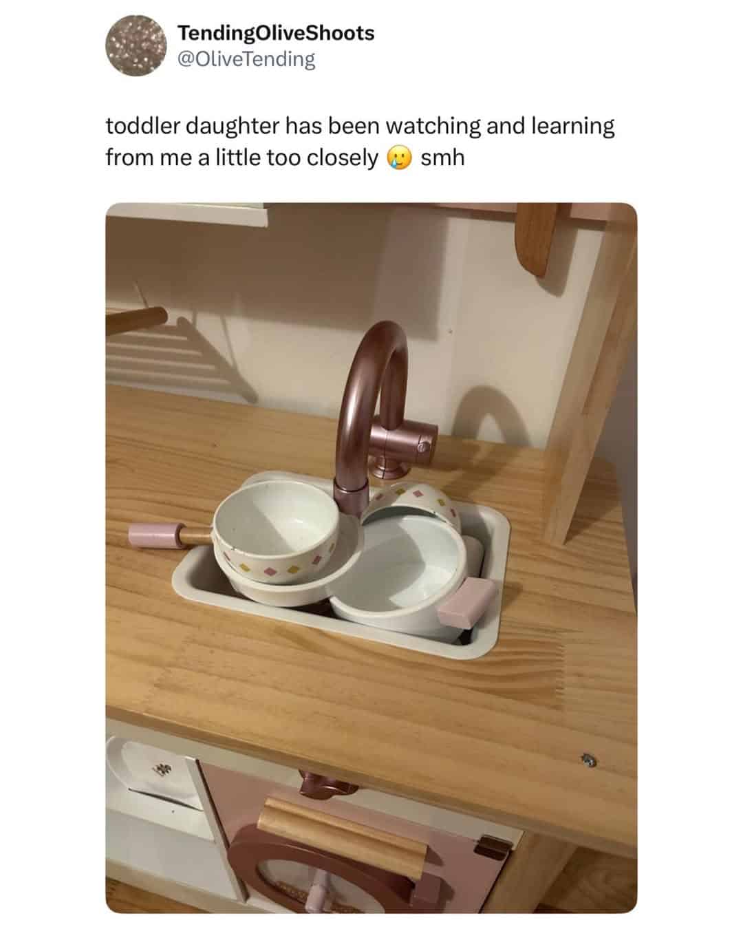 A british meme of a toddler mimicking washing dishes at a toy sink.