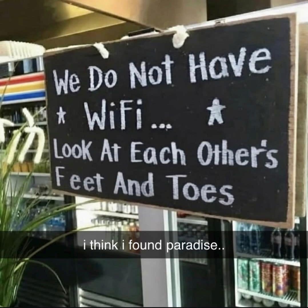 A classic meme sign at a coffee shop saying "We Do Not Have Wifi... Look At Each Other's Feet And Toes".