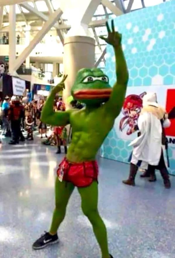 A classic meme photo of a muscular Pepe the Frog cosplayer posing at a convention.