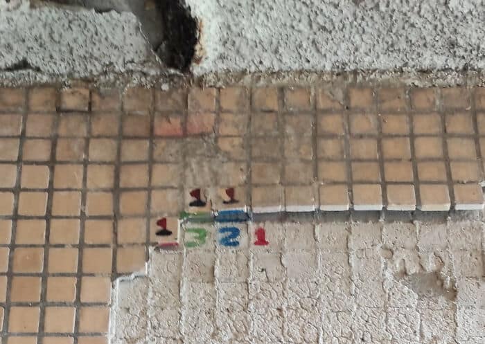 This creative vandalism features a Minesweeper level painted on a damaged tiled wall