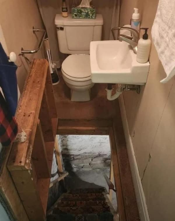 A di-why bathroom showing a toilet installed on a landing directly at the top of a staircase.