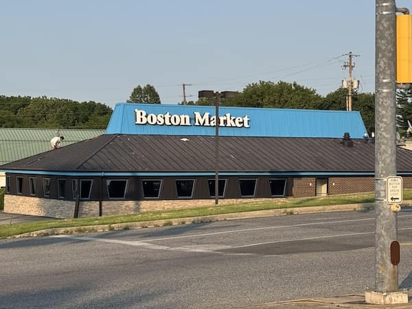 Blue roofed Boston Market operating inside a recognizable former Pizza Hut building structure.