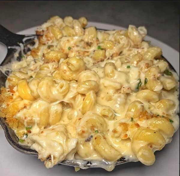 A funny cheese meme of baked macaroni and cheese in a cast iron skillet.