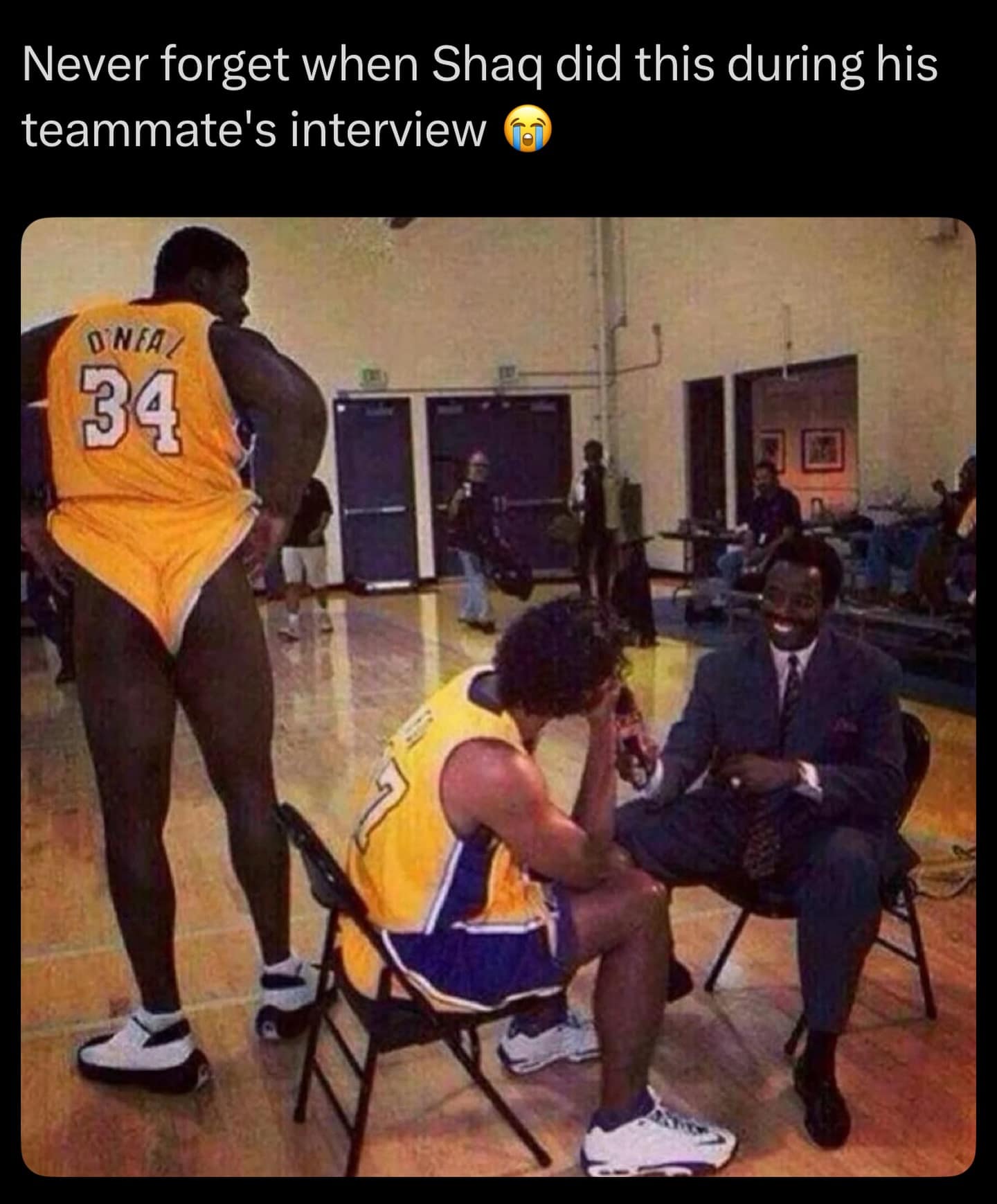 Shaq pulling shorts up high behind teammate during interview funny memes.