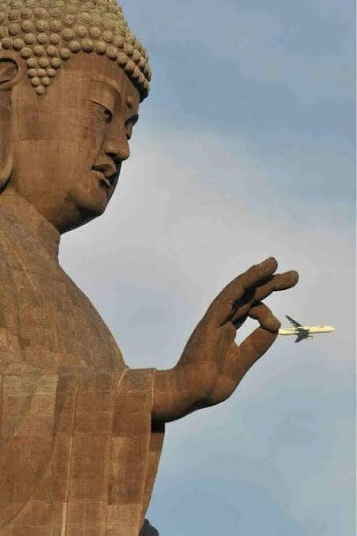 A funny optical illusion of a Buddha statue flicking a plane.