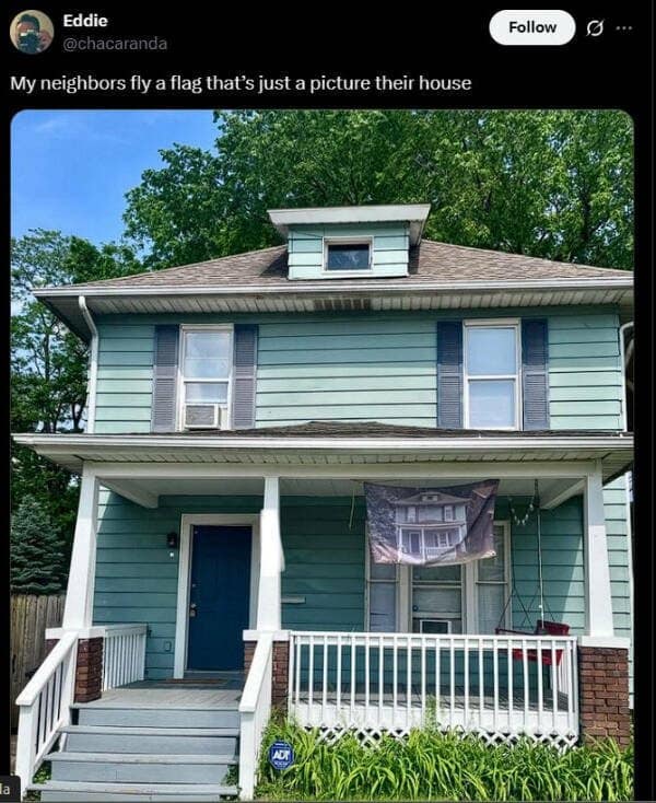 A funny pic of a house flying a flag that has a picture of the house on it.