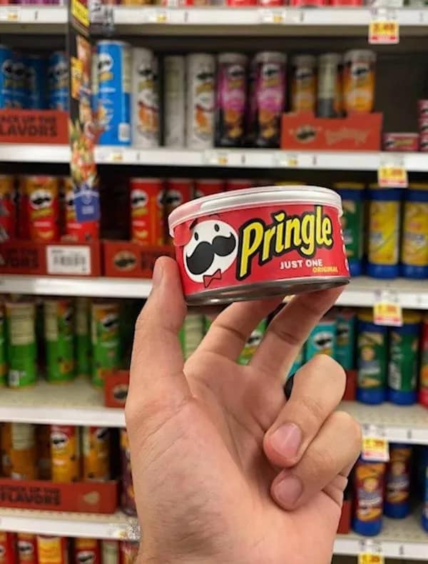Hand holding single-serving Pringles container labeled Just One.