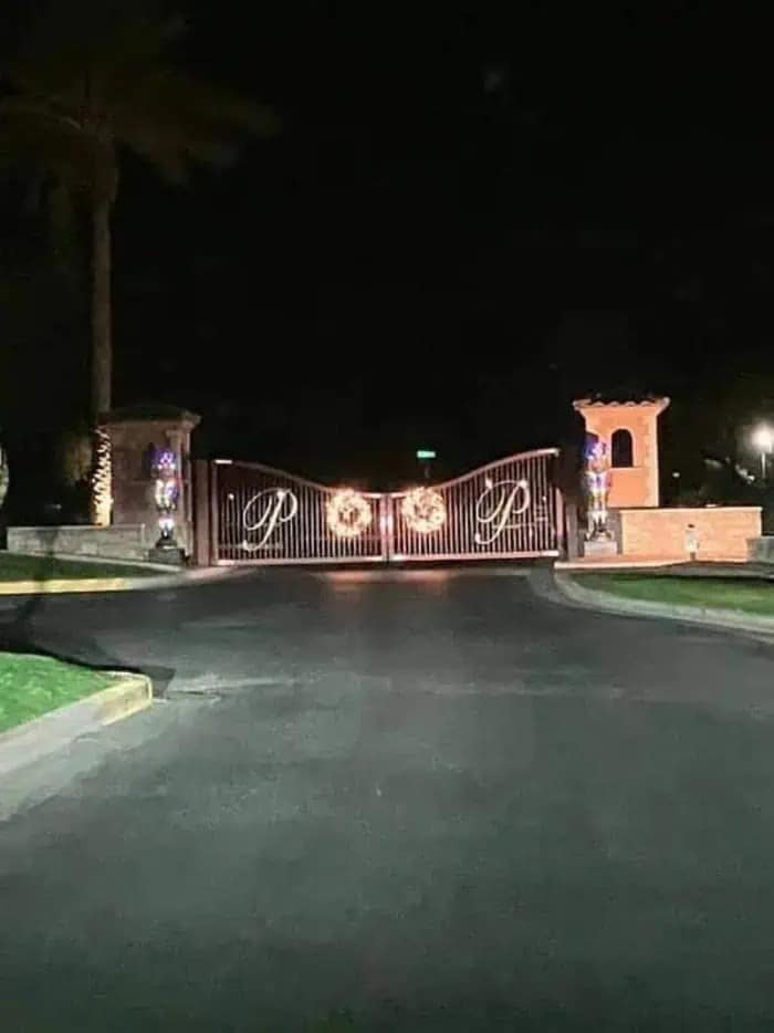 Lighted Christmas wreaths on a gated community entrance that accidentally spell the word poop.