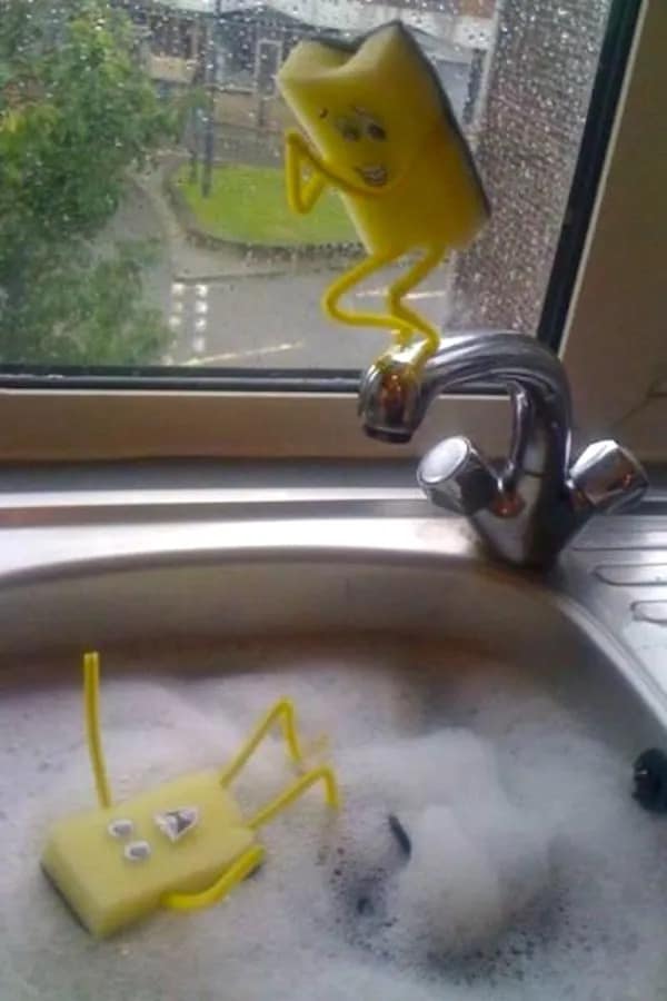 Kitchen sponges with stick figure limbs enacting a dramatic diving scene into a sink.
