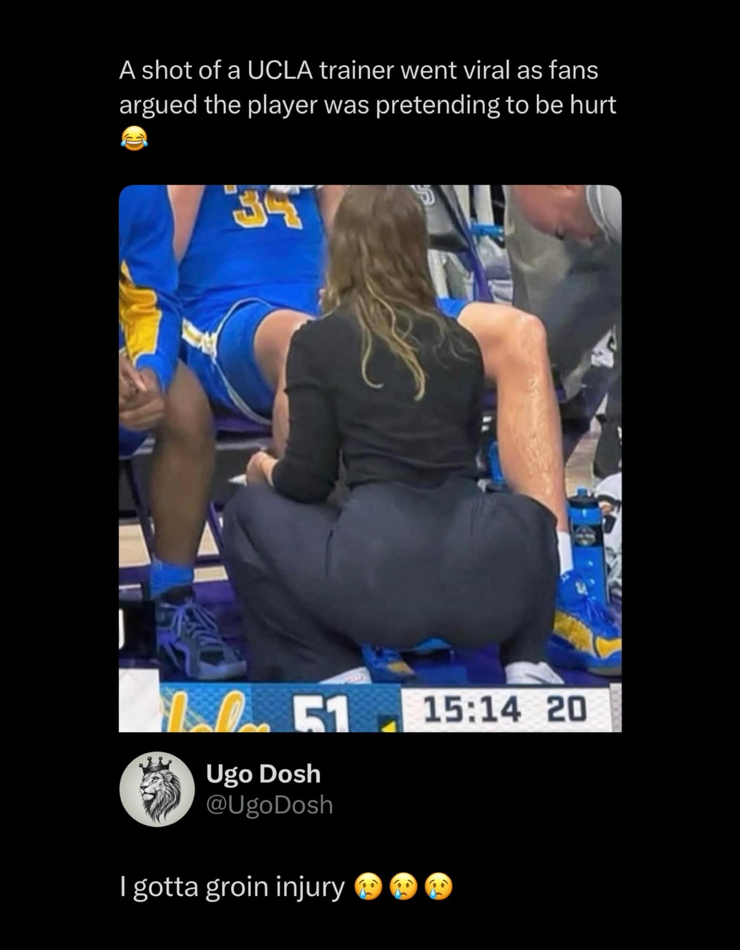 UCLA athletic trainer squatting in front of a seated basketball player.