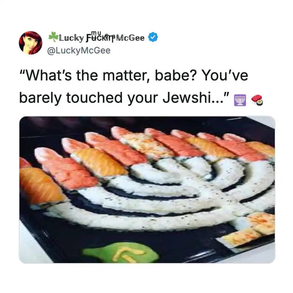 Sushi rolls arranged on a black platter in the shape of a Hanukkah menorah.