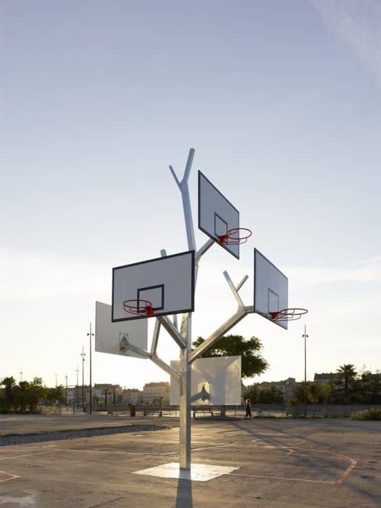 Metal tree structure with multiple basketball hoops branching out at different heights.