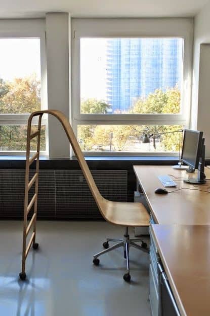 Wooden chair with an absurdly long backrest stretching all the way to the floor.