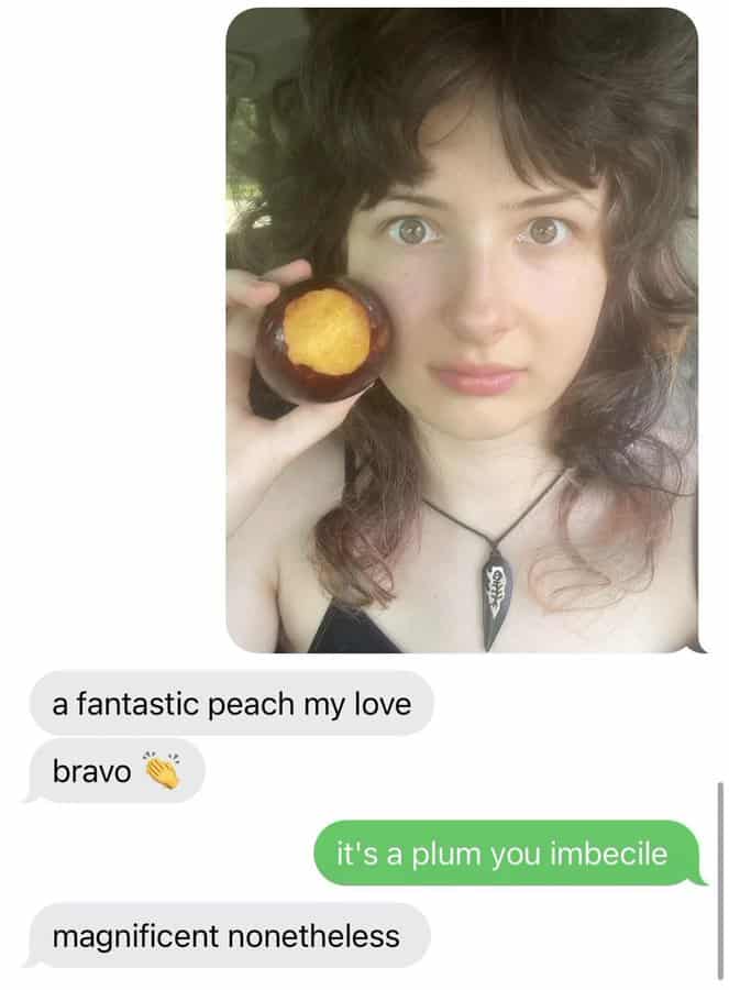 Woman holding a plum correcting a compliment in a funny text