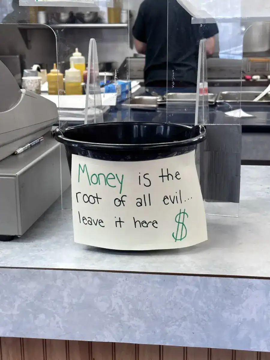 A creative tip jar bucket joking that money is the root of all evil so leave it there.