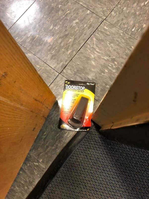 Packaged doorstop wedged under door to hold it open without unpacking.