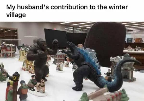 A funny meme of King Kong and Godzilla figures fighting in a Christmas winter village display.