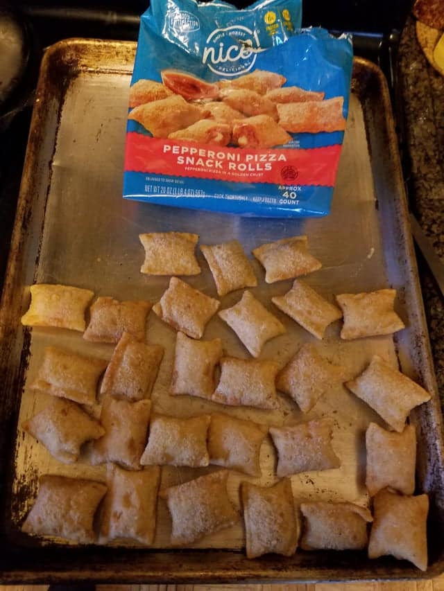 A large bag of pizza rolls next to a baking sheet showing the small amount of actual product.