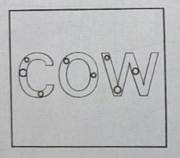 The word COW written with small circular holes inside the letters.