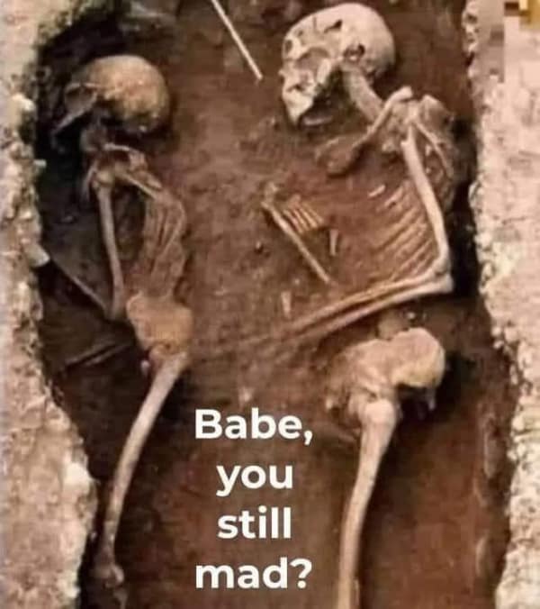 A relationship meme showing two skeletons in a grave asking if the other is still mad.