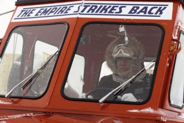 A Star Wars behind the scenes photo of Harrison Ford driving a snowcat labeled The Empire Strikes Back.
