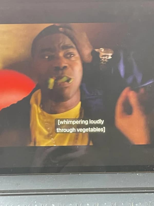 Tracy Morgan character whimpering while eating vegetables in a funny television caption error scene.