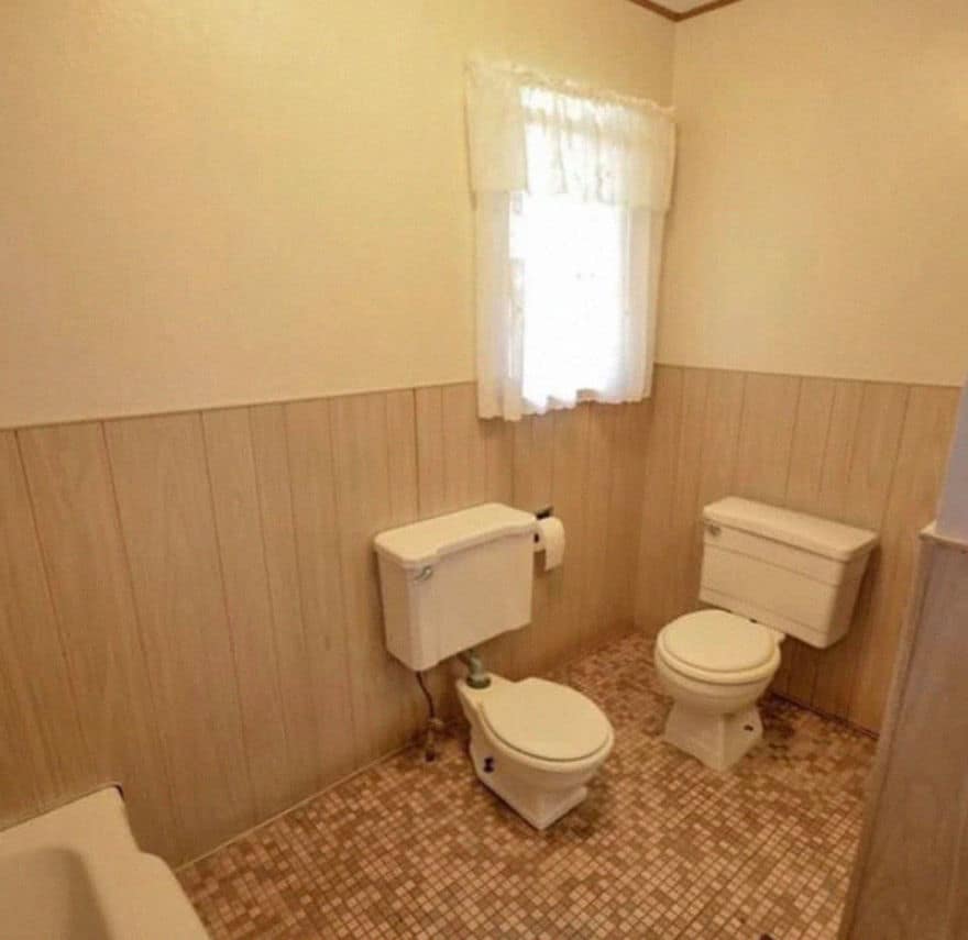 Small beige bathroom featuring two toilets installed right next to each other.