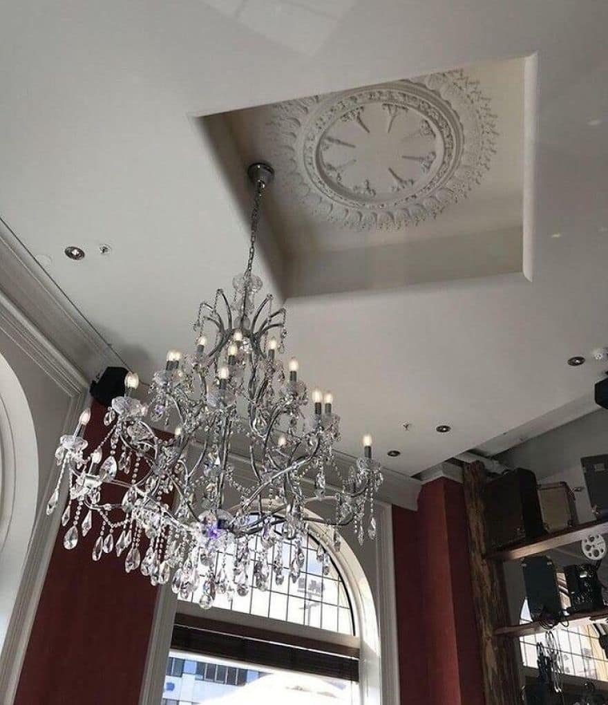 Crystal chandelier hanging several inches away from the center of the ceiling medallion.