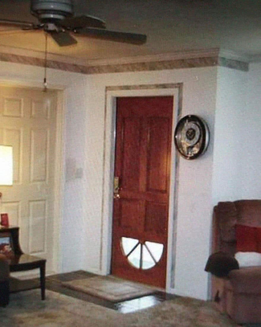 Wooden exterior door installed upside down with the window section at the bottom.