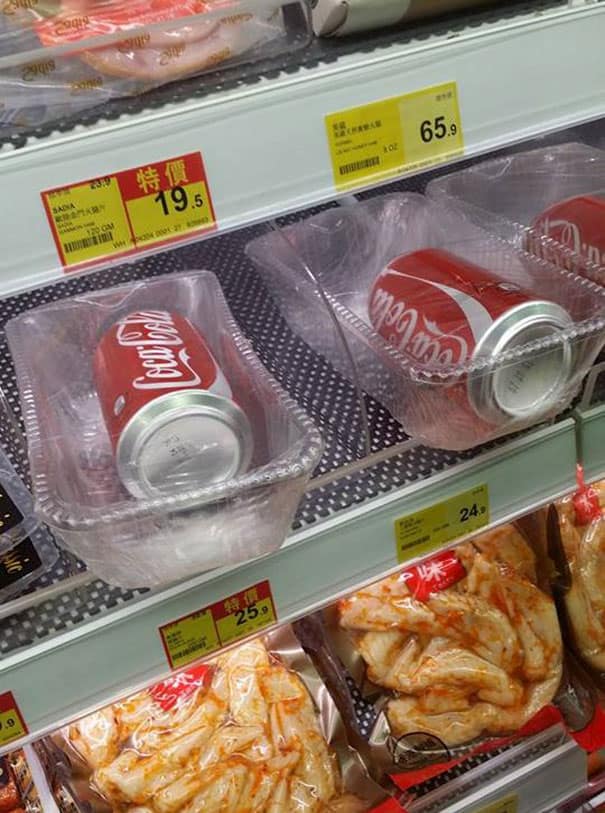 An unnecessary packaging fail showing individual Coke cans wrapped in plastic trays