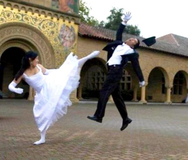Bride high kicking groom in face and knocking off his top hat.