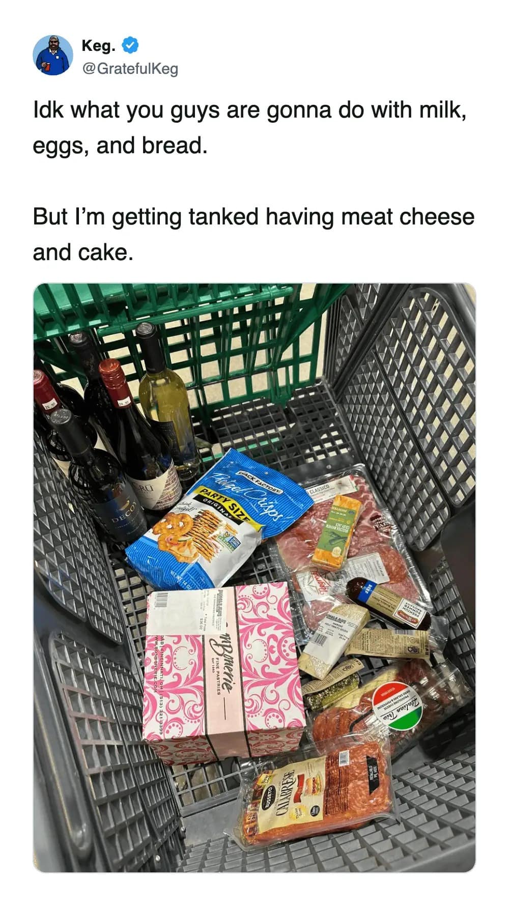 2026 winter storm meme showing a tweet about storm shopping, with a cart full of meat, cheese, cake, snacks, and drinks instead of milk and bread.