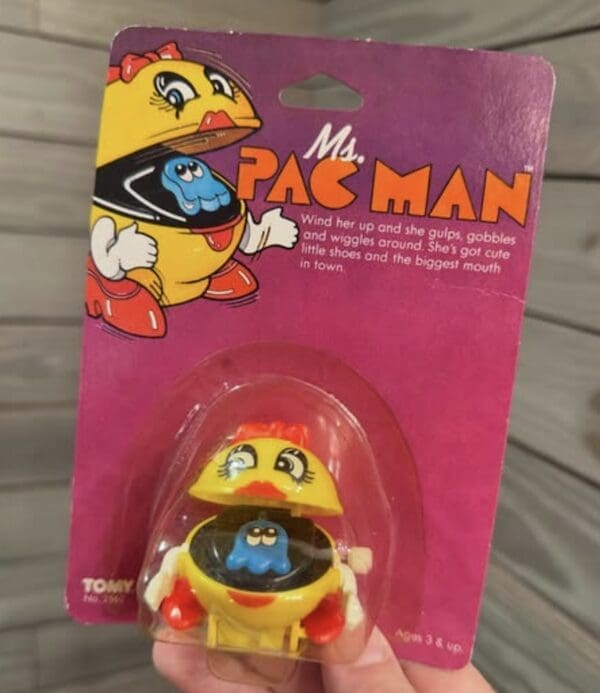 A vintage Ms. Pac-Man wind-up 90s toy still in its original pink blister packaging.