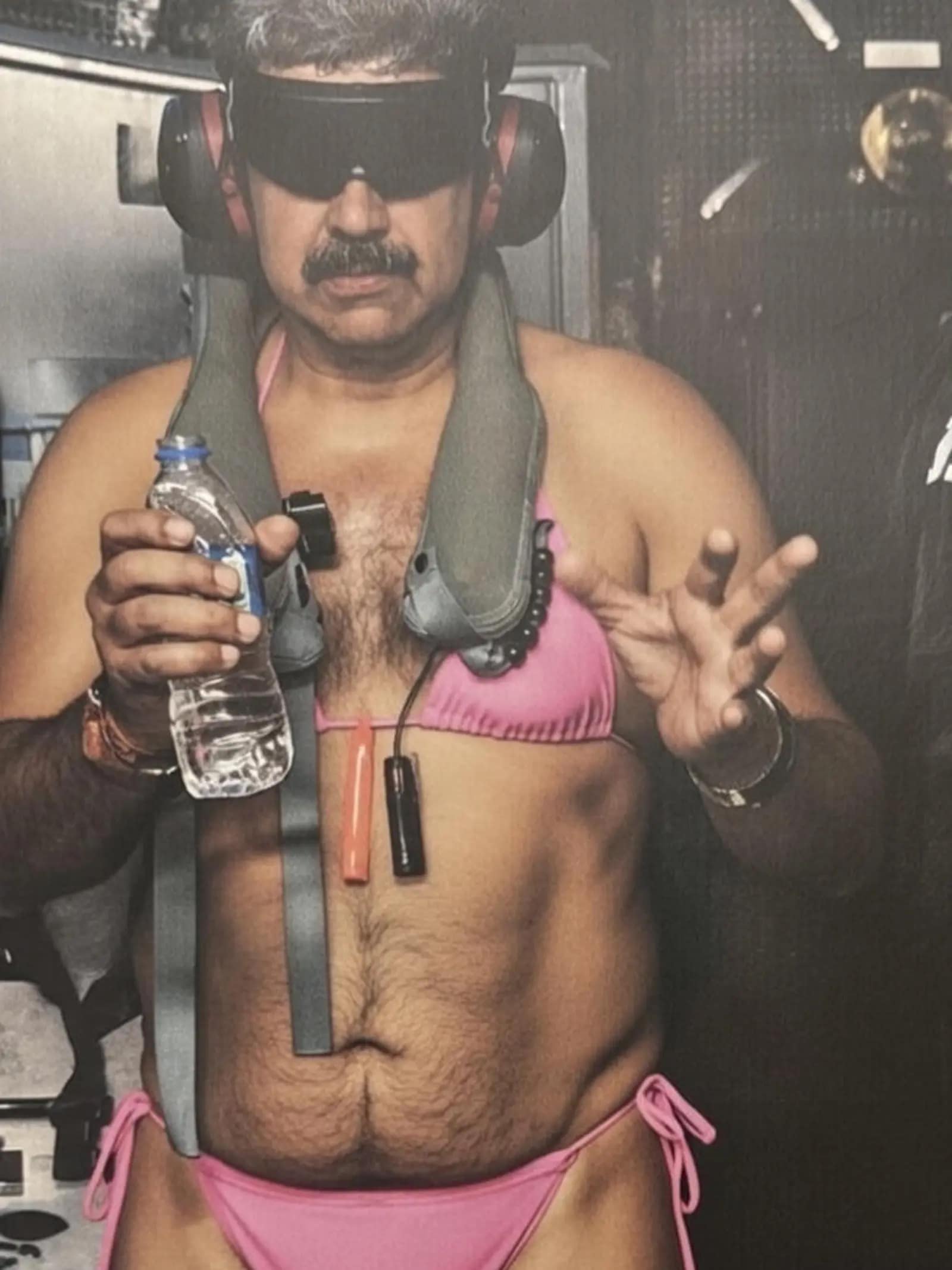 A funny photoshop of Nicolas Maduro wearing a pink bikini top and bottom while holding a water bottle.