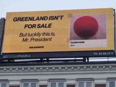 A Trump Greenland meme billboard advertising a red clown nose for sale to the President instead of the island.