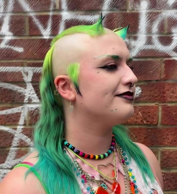 A bad haircut featuring a shaved head with neon green dyed horns and sideburns.